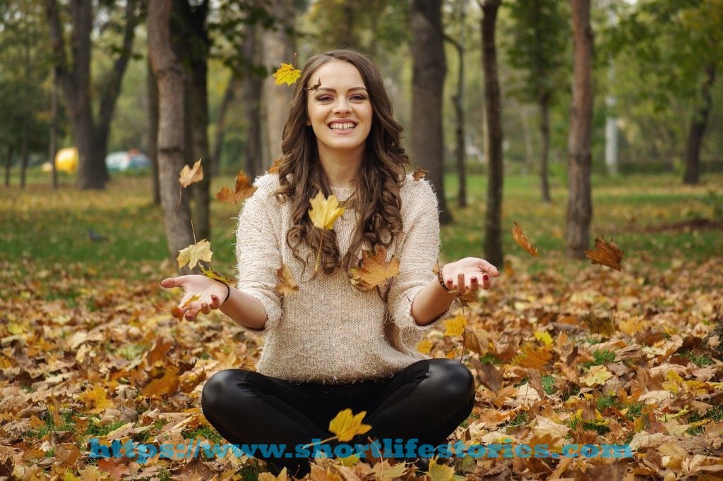 beautiful girl, in the park, throwing leaves